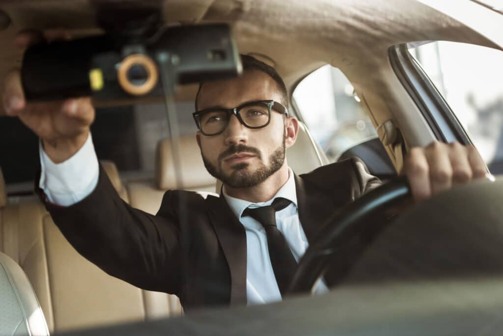 chauffeur privé qui règle son rétroviseur intérieur